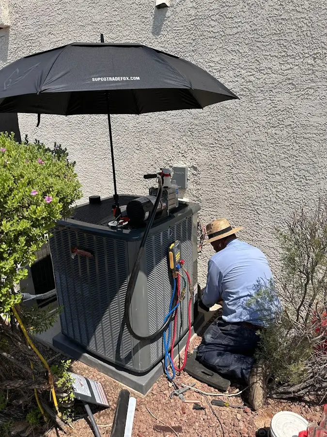 HVAC technician performing outdoor AC maintenance in Nuevo